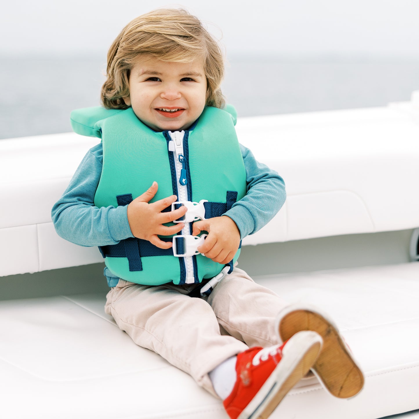 kids green life jacket on boat, searock
